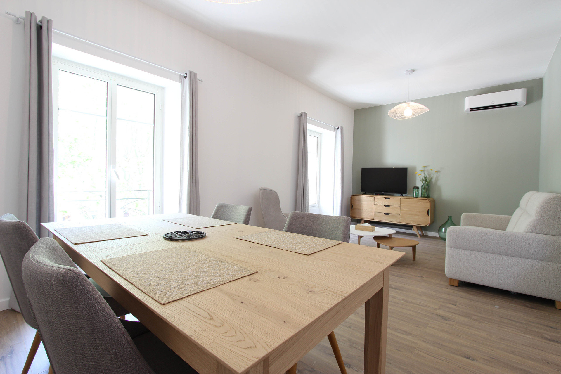 Un bel espace salon lumineux avec vue sur la place de l'école