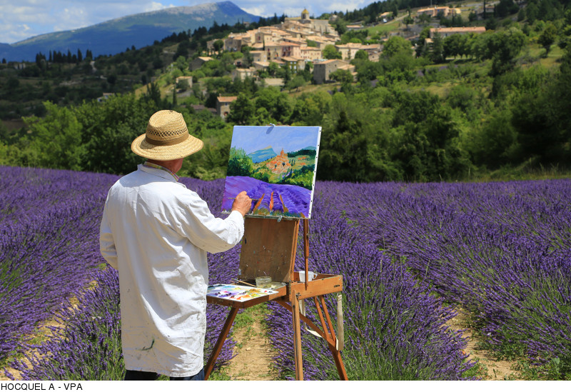 Peintre peignant le champs de lavande en contrebas du village provençal d'Aurel