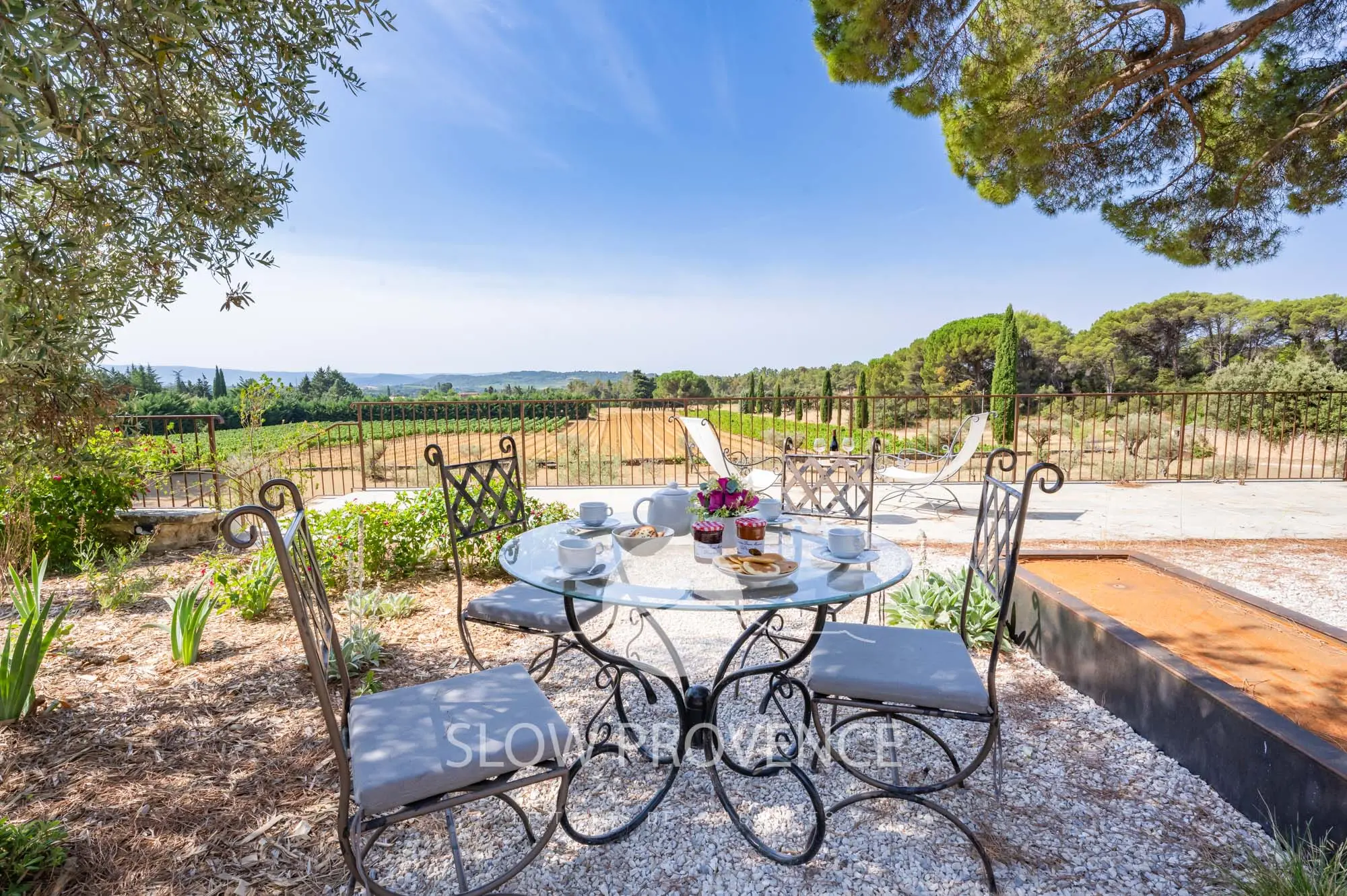 Espace repas extérieur avec vue sur le jardin et les vignes