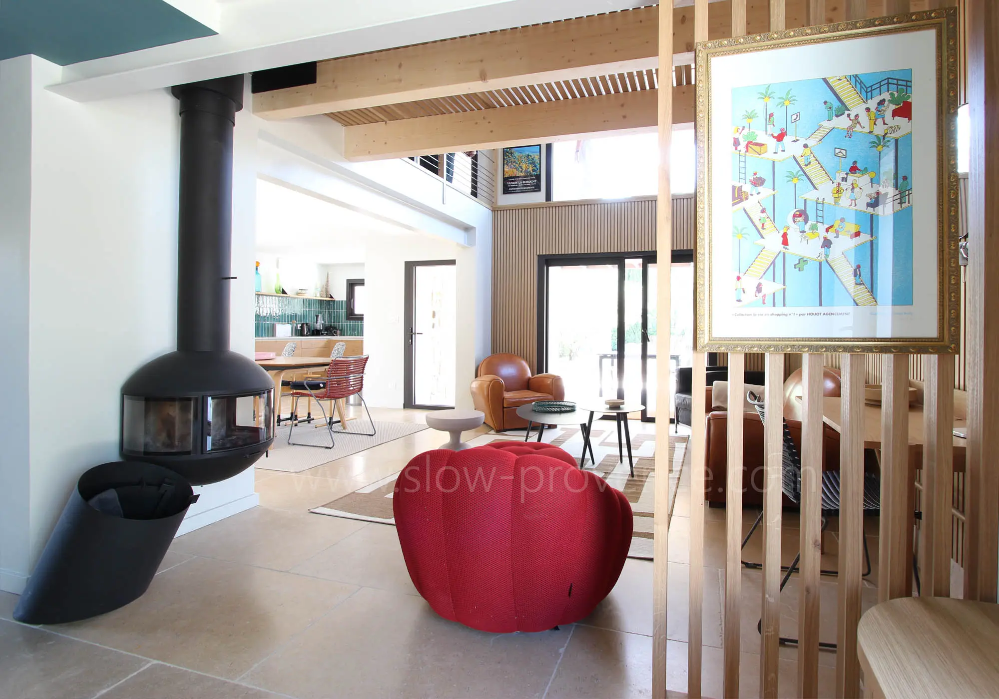 Woonkamer met hangende houtkachel, open naar de eetkamer.