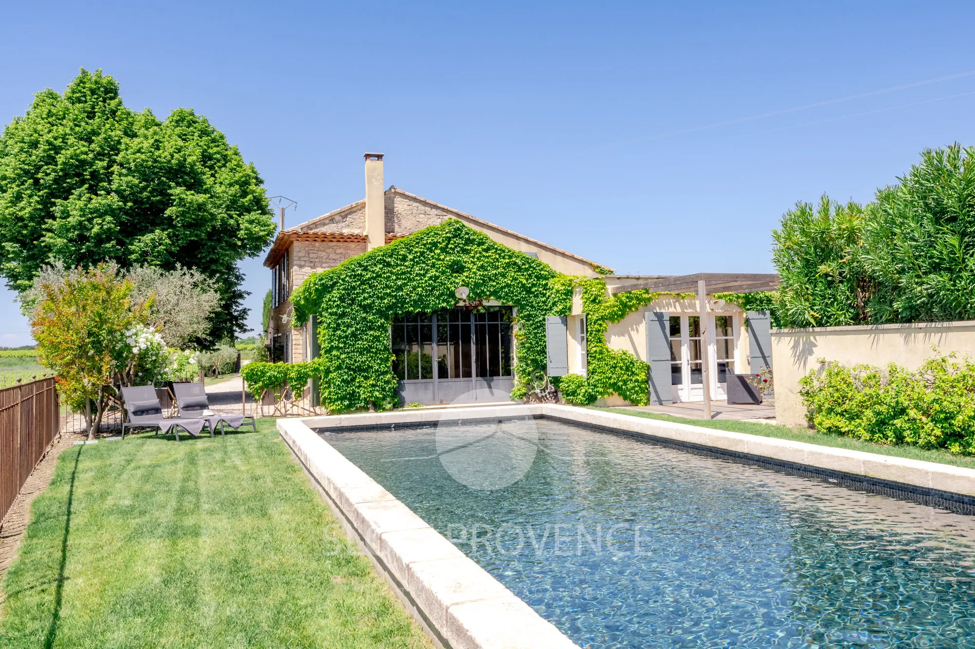 Une belle piscine ensoleillée et clôturée